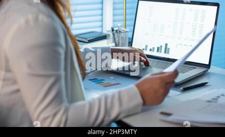 Überarbeitungs-Konzept die Frau, die ihre Arbeit spät in der Nacht macht, indem sie Papiere liest und sie auf das Notizbuch schreibt. Stockfoto