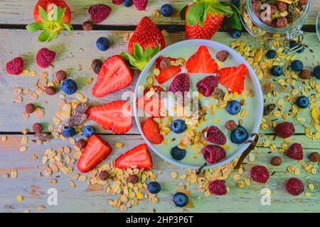 Zusammensetzung eines typischen echten Frühstücks mit Joghurt, Heidelbeeren, Himbeeren, Heidelbeeren, Müsli. Konzept von: Fitness, Ernährung, Wellness und b Stockfoto