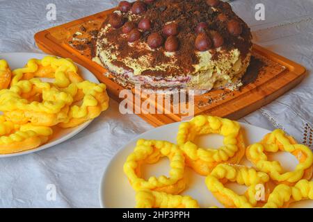 Schokoladenkuchen mit Kirschen, geriebener Schokolade und Sahne. Hausgemachter Windbeutel auf festlichen Tisch. Stockfoto