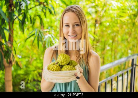 Cherimoya in einer wiederverwendbaren Tasche in weiblichen Händen. Null-Abfall-Konzept, plastikfreies Konzept. Gesunde, saubere Ernährung und Entgiftung. Sommerfrüchte Stockfoto