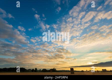 Altocumulus Wolken geben einen attraktiven Sonnenuntergang über einem Feld geernteter Getreideernte in West Yorkshire Stockfoto