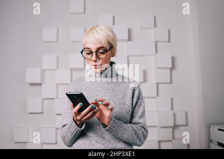 Junge Frau im Chat auf Handy Stockfoto