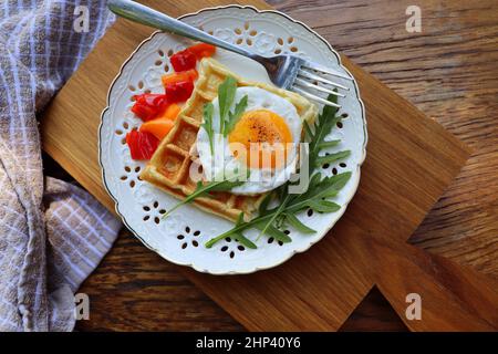 Gesundes Frühstück. Frisch zubereitetes, leckeres Gericht mit Eiern und Gemüse. Glutenfreie Buchweizen-Waffeln mit Spiegelei. Stockfoto