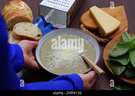 Grüner Frühling, Sommer gesunde Sahnesuppe von Sauerampfer mit Parmesan-Käse, leckeres hausgemachtes Abendessen . Stockfoto