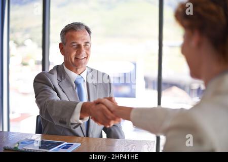 Vergnügen, Geschäfte mit Ihnen zu machen. Aufnahme eines Geschäftsmannes, der einem Kollegen im Sitzungssaal die Hand schüttelt. Stockfoto