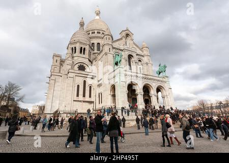 Paris , Frankreich - 21. Februar 2010: Menschen, die um die Basilika Sacre-Coeur auf dem Gipfel des Hügels von Montmartre spazieren Stockfoto