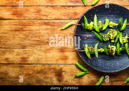 Gemüsekebab mit Brokkoli, grünen Erbsen und Okra.Veganer Spieß auf Stick.Platz kopieren Stockfoto