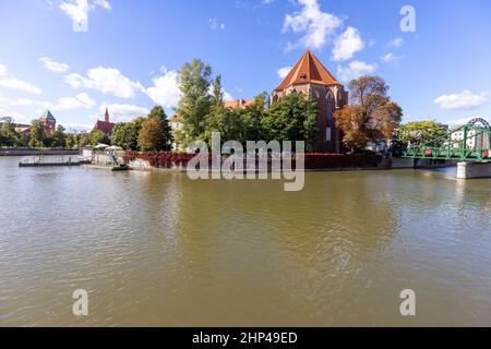 Breslau, Polen - 30. September 2021: Blick auf den Fluss oder und die Kirche der Hl. Maria auf dem Sand auf der Insel Piasek von Ostrow Tumski. Stockfoto