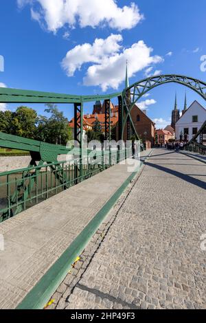 Breslau, Polen - 30. September 2021: Blick auf die Tumski-Brücke, die Türme der Stiftskirche des Heiligen Kreuzes und die Kathedrale St. Bartholomäus und Breslau Stockfoto