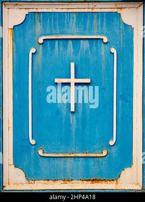Altes Metallkreuz auf blauer Tür christian Symbol Stockfoto
