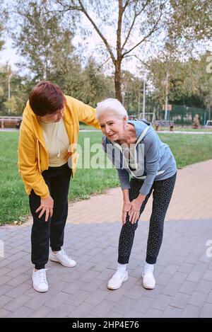 Zwei ältere Frauen, die im Park Sport treiben, Herzinfarkt Stockfoto