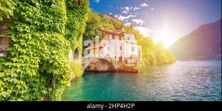 Stadt Nesso historische Steinbrücke und landschaftlich schönen See Sonnendunst Panoramablick, Como See, Lombardei Region von Italien Stockfoto