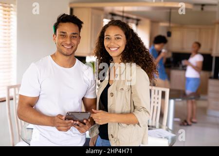 Porträt eines lächelnden jungen biracial Geschäftsmann und Geschäftsfrau mit digitalem Tablet im Home Office Stockfoto