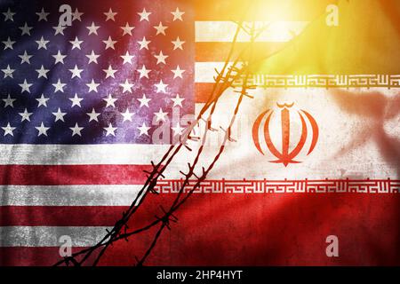 Grunge-Flaggen des Iran und der USA geteilt durch Stacheldraht-Sonnendunst-Illustration, Konzept der angespannten Beziehungen zwischen dem Iran und den USA Stockfoto