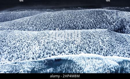 Luftaufnahme der Wellen am schwarzen Sandstrand von Vestrahorn, Südisland. Drohne von direkt über dem Kopf geschossen. Stockfoto