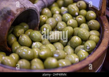 Gefüllte grüne Oliven in einer alten Holzschüssel Stockfoto