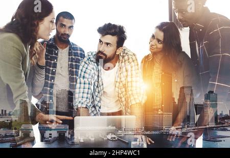 Einen Aktionsplan formulieren. Digital verbesserte Aufnahme einer Gruppe von Kollegen, die sich um einen Laptop im Büro versammelt haben. Stockfoto