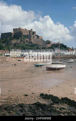 1960s, historische Ansicht für diese Ära von Mont Orgueil Castle und Bucht in Gorey, Jersey, im 13th. Jahrhundert von König John von England gebaut, als Festung, um die Inseln zu verteidigen. Stockfoto