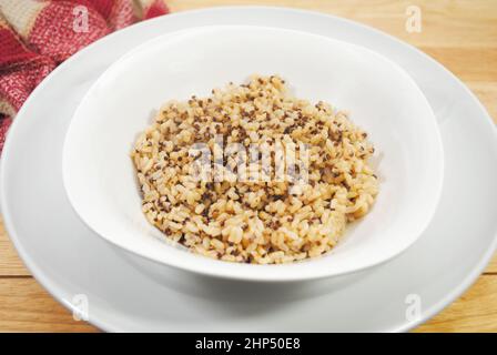 Eine Beilage aus gedämpftem Quinoa und braunem Reis in einer weißen Schüssel Stockfoto