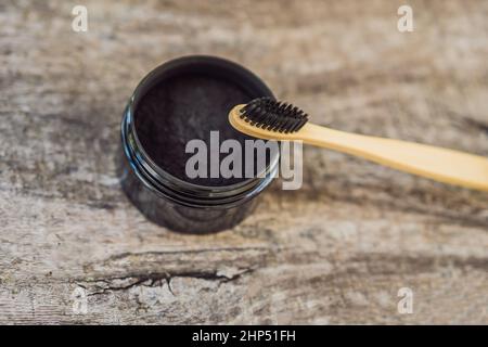 Aktivkohlepuder zum Zähneputzen und Aufhellen. Bamboo Eco-Bürste Stockfoto