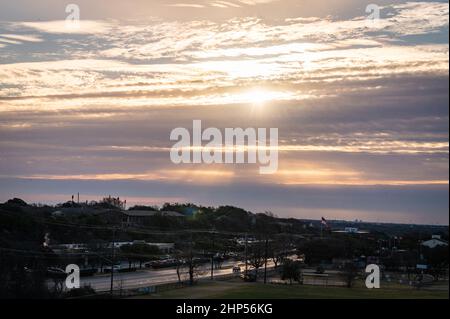 Austin, Texas, USA. 18. Februar 2022. Austin erwacht zu eiskalten Temperaturen. Sonnenaufgang auf dem Murchison Hill im Nordwesten von Austin, während Menschen, die sich für kaltes Wetter kleiden, ihren Weg zur Arbeit finden. . Kredit: Sidney Bruere/Alamy Live Nachrichten Stockfoto