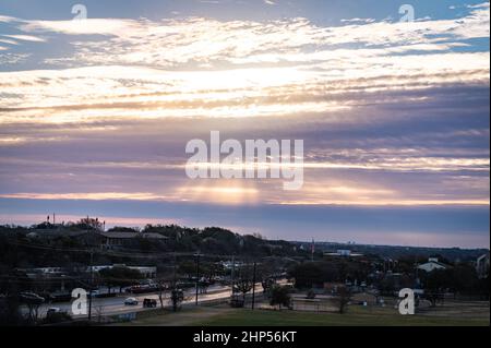 Austin, Texas, USA. 18. Februar 2022. Austin erwacht zu eiskalten Temperaturen. Sonnenaufgang auf dem Murchison Hill im Nordwesten von Austin, während Menschen, die sich für kaltes Wetter kleiden, ihren Weg zur Arbeit finden. . Kredit: Sidney Bruere/Alamy Live Nachrichten Stockfoto