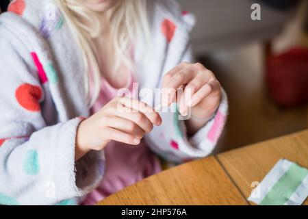 Kind testet sich zu Hause auf Coronavirus. Rapid COVID-19 Antigen Testkit für Selbsttests. Stockfoto