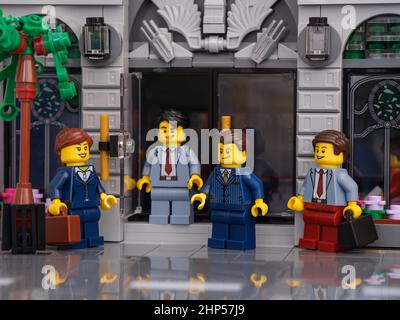 Tambow, Russische Föderation - 13. Februar 2022 Ein Lego-Geschäftsmann minifiguren Treffen auf der Straße vor einer Bank. Eine der Minifiguren ist c Stockfoto