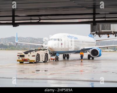 Russland, Sotschi 02.11.2021. Am Flugplatz steht ein mit einem Verkehrsflugzeug verbundener Flughafenschlepper mit der Aufschrift Victory. Stockfoto