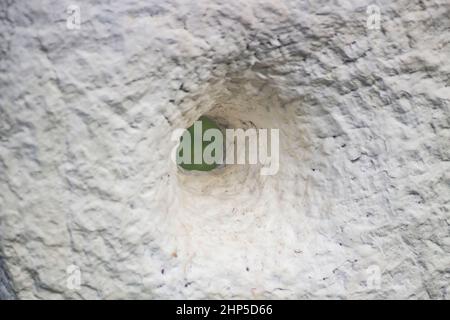 Loch in Stuck. Details der Skulptur. Weiße Wand mit Loch. Raue Oberfläche aus Stein.