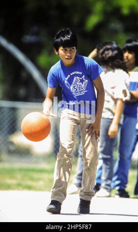 San Antonio, Texas USA, 1993: Hispanische Schüler spielen Basketball in der Pause. ©Bob Daemmrich Stockfoto