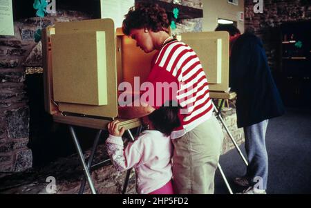 Austin Texas USA, 1995: Wahlstimmerin bei der Kommunalwahl in Austin mit ihrem kleinen Kind an ihrer Seite. ©Bob Daemmrich Stockfoto