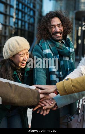 Gruppe von Geschäftskollegen, die im Freien ihre Hände zusammenlegen. Stockfoto