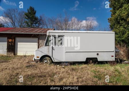 Horizontale Seitenaufnahme eines verlassenen weißen LKW mit einer leeren Seite mit Kopierraum. Stockfoto