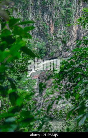 Foto zeigt eine felsige Schlucht, in der ein Gebirgsfluss fließt. Der Fluss fließt durch riesige Steinblöcke. Die bezaubernde Tierwelt der karibischen Insel begeistert Stockfoto