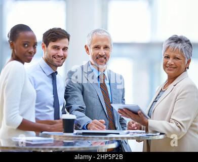 Dieses Team wird die Arbeit erledigen. Porträt einer Gruppe verschiedener Geschäftsleute, die im Büro ein Meeting abhalten. Stockfoto