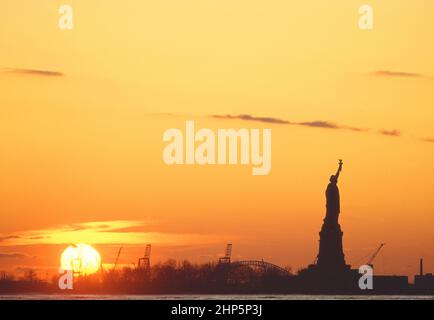 Freiheitsstatue Sonnenuntergang oder goldene Stunde im Hafen von New York. Amerikanisches Wahrzeichen-Denkmal auf Liberty Island. Port Elizabeth New Jersey. Amerikanische Kultur USA Stockfoto