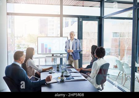 HES ein Profi bei Präsentationen. Ausgeschnittene Aufnahme eines Geschäftsmanns, der in einem Sitzungssaal eine Präsentation vorführt. Stockfoto