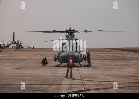 US-Marineinfanteristen mit Marine Light Attack Helicopter Squadron (HMLA) 369 führen ihre letzten Kontrollen an einem U.S. Marine Corps UH-1Y Venom Hubschrauber durch, bevor sie während der Jungle Warfare Übung (JWX 22) an der Marine Corps Air Station Futenma, Okinawa, Japan, 16. Februar 2022 starten. JWX 22 ist eine groß angelegte Schulung vor Ort, die sich auf die Nutzung der integrierten Fähigkeiten gemeinsamer und verwandter Partner konzentriert, um das Bewusstsein für alle Bereiche, Manöver und Brände in einer verteilten maritimen Umgebung zu stärken. (USA Meeresfoto von Lance CPL. Kyle Chan) Stockfoto