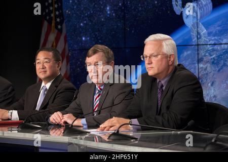 Im Zuschauerraum der Pressestelle des Kennedy Space Center der NASA in Florida sprechen NASA und Branchenführer bei einer Pressekonferenz nach dem Start von Orbital ATK CRS-4, einer kommerziellen Mission zur Wiederaufversorgung der Internationalen Raumstation (ISS), mit den Medien. Von links sind der Ehrw. Feng, Manager des ISS Transportation Integration Office, des Johnson Space Center der NASA, Frank Culbertson Jr., Präsident der Orbital ATK Space Systems Group, und Vernon Thorpe, Programmmanager der United Launch Alliance für NASA-Missionen Ca. 2015 Stockfoto