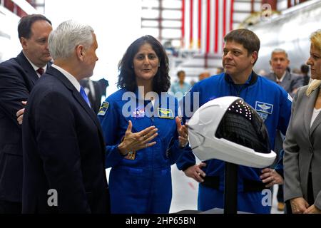 Vizepräsident Mike Pence, links im Vordergrund, führt am 21. Februar 2018 durch den SpaceX-Hangar im Launch Complex 39A im Kennedy Space Center der NASA in Florida. Die NASA-Astronauten Suni Williams und Bob Behnken beschreiben die Art des Druckanzüge-Helms, der bei der Fahrt der Besatzung zur Internationalen Raumstation an Bord der Crew Dragon-Raumsonde des Unternehmens getragen werden muss. Hinter Pence steht der amtierende NASA-Administrator Robert Lightfoot. Ganz rechts ist SpaceX President und COO Gwynne Shotwell. Während seines Besuchs leitete Pence ein Treffen des Nationalen Weltraumrats in der Hochbucht der Raumstation Processing Fa des Zentrums Stockfoto