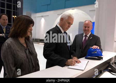 Vizepräsident Mike Pence, Zentrum, unterschreibt ein Gästebuch während seiner Tour durch die Blue Origin Manufacturing Facility in der Nähe des Kennedy Space Centers der NASA in Florida am 20. Februar 2018. Links steht die Frau der Vizepräsidentin, Karen Pence. Rechts von ihm ist Robert Smith, CEO von Blue Origin. Hinter ihnen steht der amtierende NASA-Administrator Robert Lightfoot. Vice President Pence sah sich den geflogenen New Shepard Booster und die Crew Capsule an. Der Booster war das erste Trägerrakete mit einem erfolgreichen vertikalen Start und einer vertikalen Landung, um die Wiederverwendbarkeit zu demonstrieren. Stockfoto