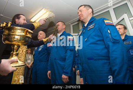 Expedition 47 Sojus-Kommandant Alexei Ovchinin von Roskosmos, Mitte, erhält den traditionellen Segen eines russisch-orthodoxen Priesters im Kosmonauten-Hotel vor seinem Start mit der Sojus-Rakete zur Internationalen Raumstation (ISS) am Freitag, den 18. März 2016 in Baikonur, Kasachstan. Ovchinin, der Flugingenieur Jeff Williams von der NASA, links, und der Flugingenieur Oleg Skripochka von Roscosmos, rechts, werden die nächsten fünfeinhalb Monate an Bord der ISS verbringen. Stockfoto