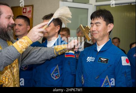 Expedition 44 der Flugingenieur Kimiya Yui von der Japan Aerospace Exploration Agency (JAXA), rechts, erhält den traditionellen Segen eines russisch-orthodoxen Priesters im Kosmonauten-Hotel vor seinem Start auf der Sojus-Rakete zur Internationalen Raumstation (ISS), Mittwoch, 22. Juli 2015, in Baikonur, Kasachstan. Stockfoto