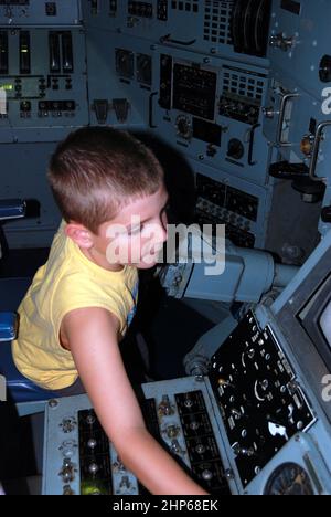 Ein kleiner Junge überprüft die Kontrollen an einem historischen U-Boot Stockfoto