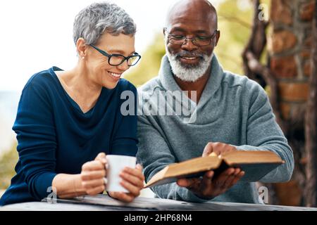 Schieß los. und lesen Sie diesen Teil. Aufnahme eines glücklichen älteren Paares, das eine schöne Zeit im Park genießt. Stockfoto