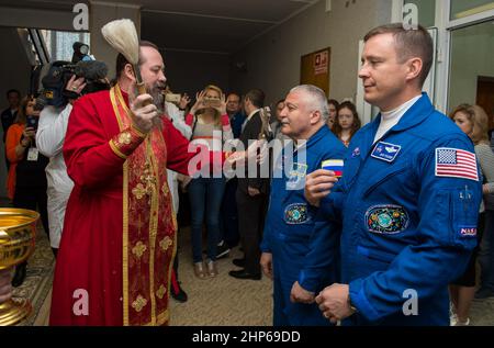 Expedition 51 Sojus-Kommandant Fjodor Jurtschichin von Roskosmos, links, erhält den traditionellen Segen eines russisch-orthodoxen Priesters im Kosmonauten-Hotel vor seinem Start mit der Sojus-Rakete zur Internationalen Raumstation (ISS), Donnerstag, 20. April 2017, in Baikonur, Kasachstan. Er und sein Mitbesatzungskollege, der Flugingenieur Jack Fischer von der NASA, rechts, werden die nächsten viereinhalb Monate an Bord der ISS leben und arbeiten. Stockfoto