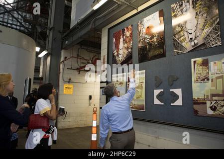 Bob Cabana, Direktor des Kennedy Space Center, zeigt auf eine Ausstellung während einer Tour für die Darsteller und Crew-Mitglieder des kommenden Filmes „Hidden Figures“. Die Gruppe geht zu Fuß, dachte der Transfergang des Fahrzeugmontagehaus ca. 2016 Stockfoto