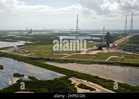 Im Kennedy Space Center der NASA in Florida erwartet die 327 Meter hohe Ares I-X-Rakete den Start auf dem Launch Pad 39B bei ihrem bevorstehenden Flugtest. In der Ferne befinden sich das Space Shuttle Atlantis auf dem Kennedy Launch Pad 39A und die Pads und Verarbeitungsanlagen auf der Cape Canaveral Air Force Station Ca. 2009 Stockfoto