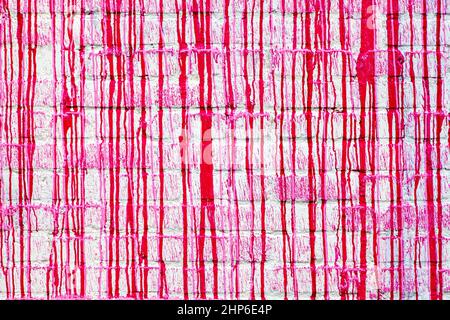 Rote Farbe tropft auf einem weißen Ziegelsteinwand abstrakt Grunge Farbe Textur Hintergrund Stockfoto